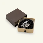 Brown custom belt box with a rolled black belt and silver buckle